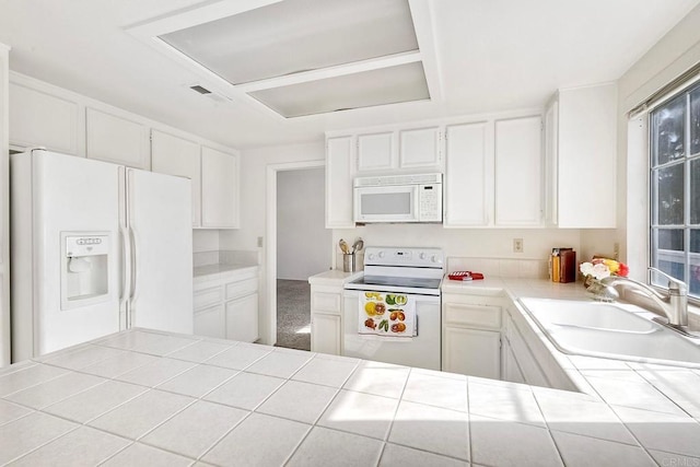 kitchen with sink, plenty of natural light, tile counters, white appliances, and white cabinets