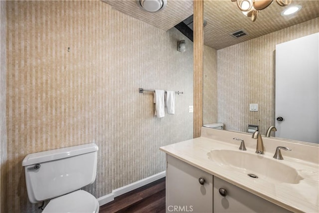 bathroom with wood-type flooring, vanity, and toilet