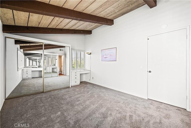 unfurnished bedroom featuring vaulted ceiling with beams, wooden ceiling, and carpet flooring