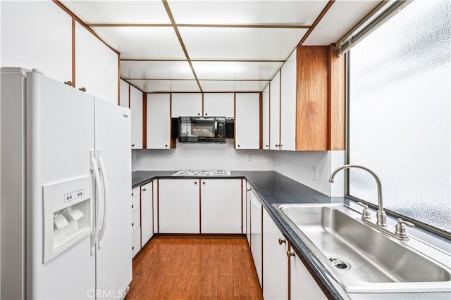 kitchen featuring sink, white cabinets, white appliances, and light hardwood / wood-style floors