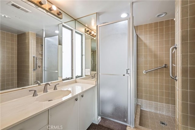 bathroom featuring vanity and a shower with shower door