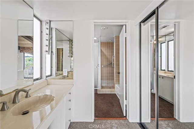 bathroom with vanity and tiled shower