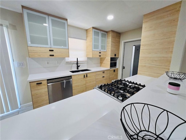 kitchen with sink, gas cooktop, backsplash, stainless steel dishwasher, and light brown cabinets