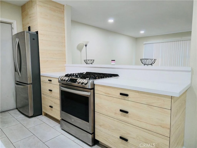 kitchen with stainless steel appliances, light brown cabinets, and light tile patterned floors