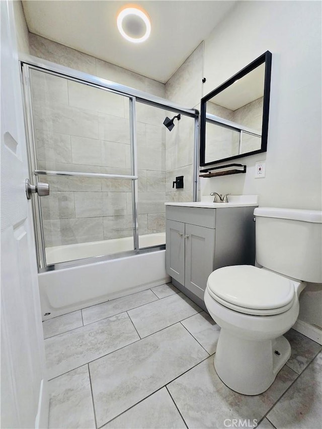 full bathroom featuring enclosed tub / shower combo, vanity, and toilet