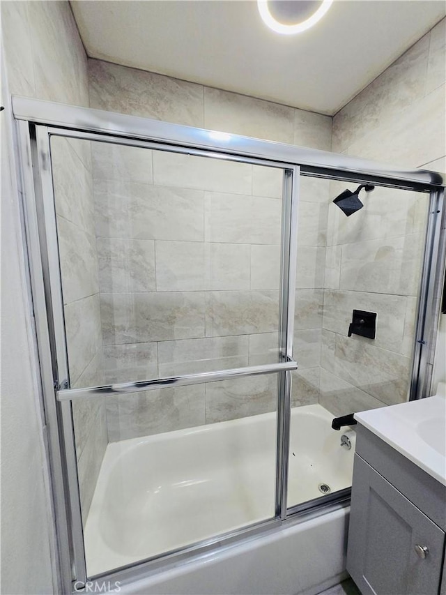 bathroom featuring vanity and combined bath / shower with glass door