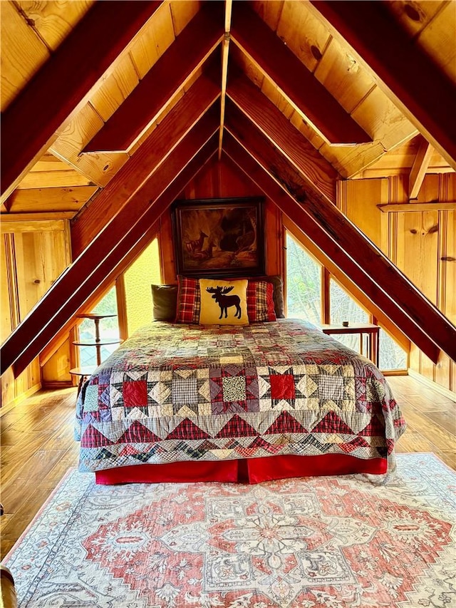 bedroom with wood walls, multiple windows, wood-type flooring, vaulted ceiling with beams, and wood ceiling