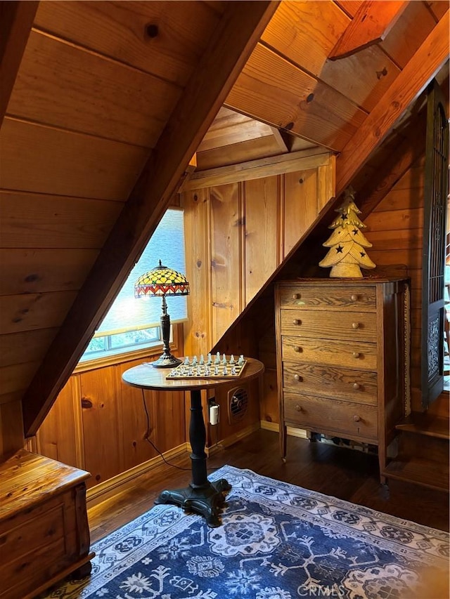 interior space featuring beam ceiling, wooden walls, wood ceiling, and wood finished floors