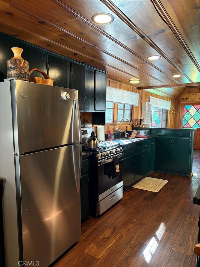 kitchen with wood ceiling, dark wood-style floors, stainless steel appliances, and wooden walls