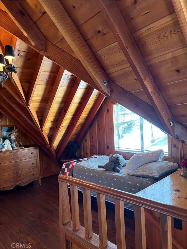 bedroom featuring lofted ceiling with beams, wood finished floors, and wooden ceiling