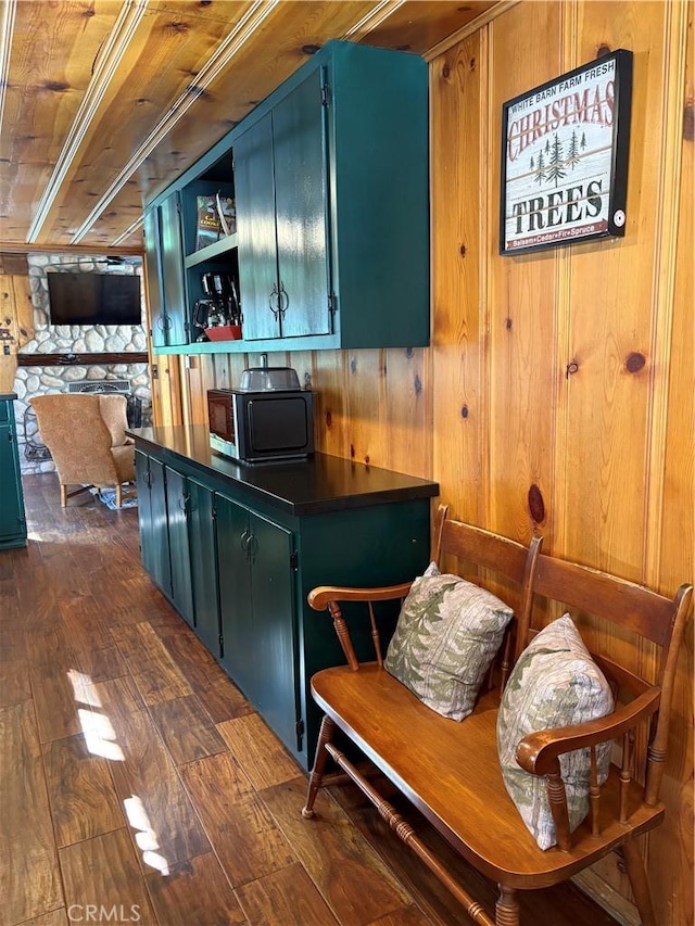 kitchen featuring open shelves, blue cabinetry, dark countertops, and dark wood-type flooring