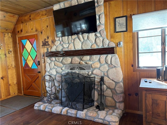 interior details with wooden walls, a fireplace, wood ceiling, and wood finished floors