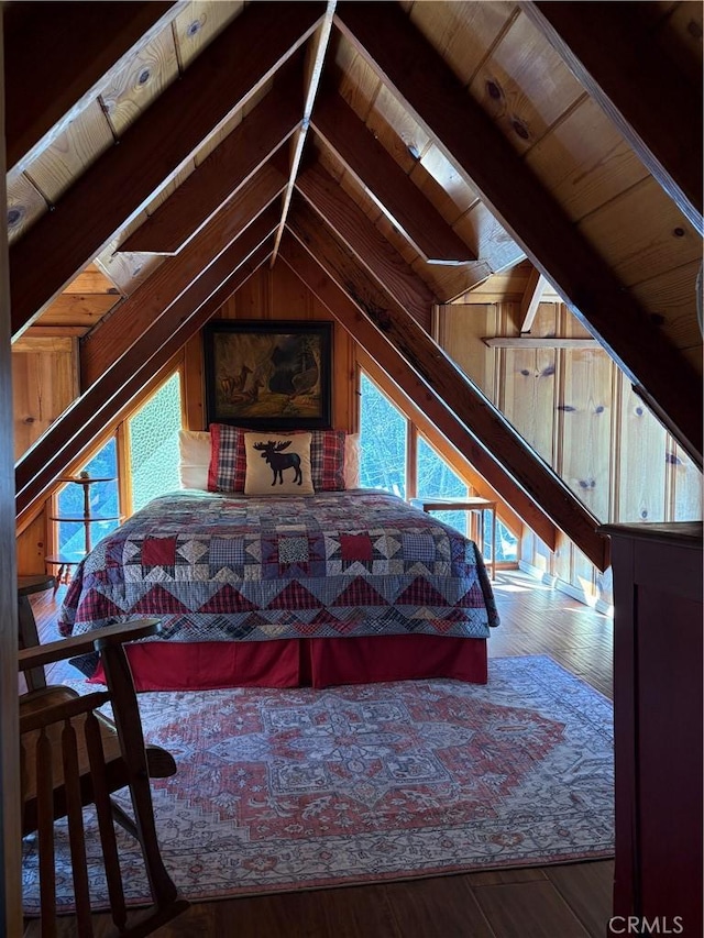 bedroom with wooden ceiling, wooden walls, wood finished floors, and vaulted ceiling with beams