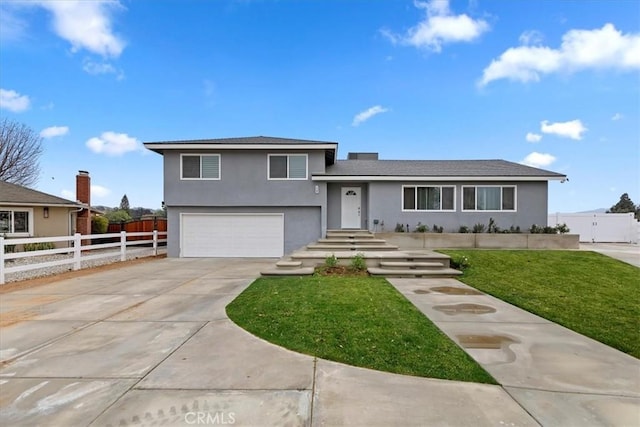 tri-level home with a garage and a front lawn