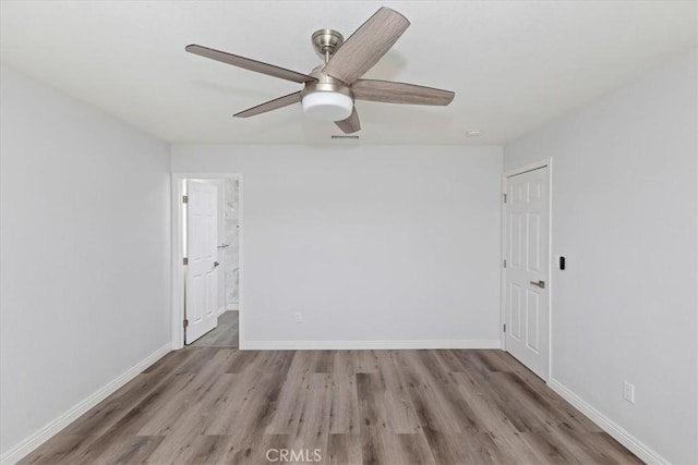 spare room featuring light hardwood / wood-style flooring and ceiling fan