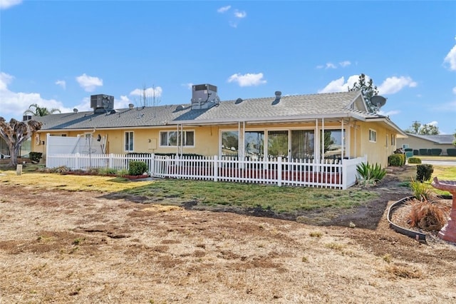 rear view of property with a garage and central air condition unit