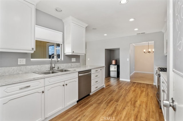 kitchen featuring pendant lighting, white cabinetry, sink, stainless steel appliances, and light wood-type flooring