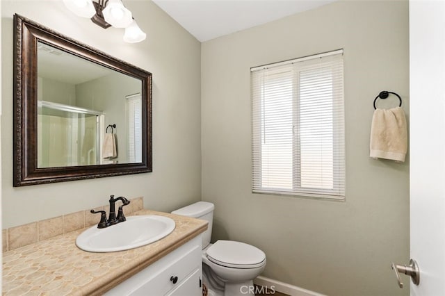 bathroom with vanity, toilet, and a shower