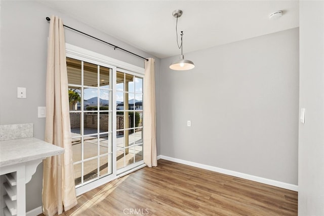 unfurnished dining area featuring hardwood / wood-style flooring and a mountain view