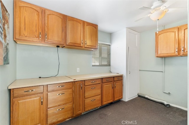 kitchen with ceiling fan and dark colored carpet