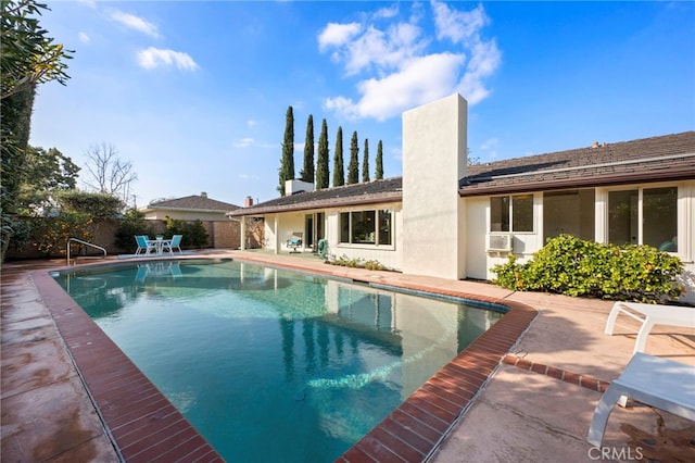 view of pool with cooling unit and a patio area