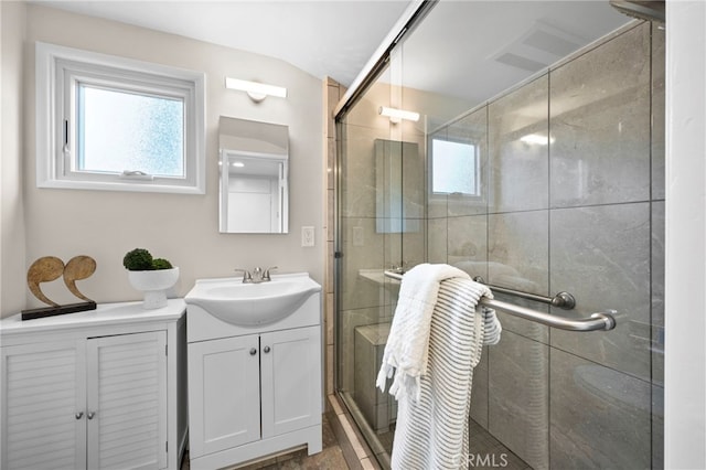 bathroom featuring walk in shower, vanity, and plenty of natural light