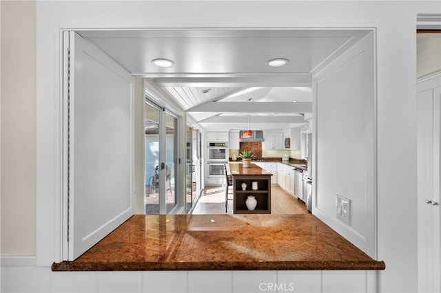 unfurnished dining area featuring vaulted ceiling with beams