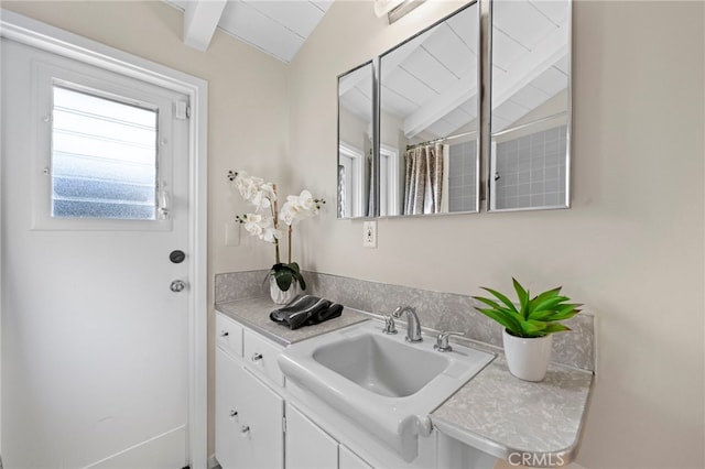 bathroom featuring lofted ceiling with beams, vanity, and a shower with curtain