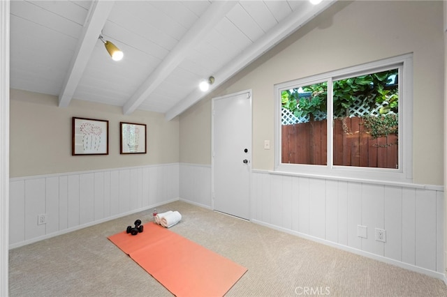 workout room with vaulted ceiling and light colored carpet