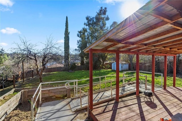 wooden deck featuring a lawn and a storage unit