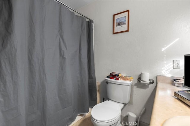 bathroom featuring vanity, toilet, and curtained shower