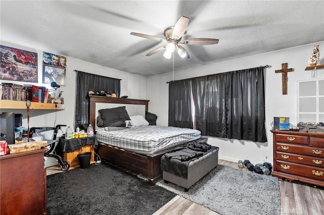 bedroom with wood-type flooring, a textured ceiling, and ceiling fan