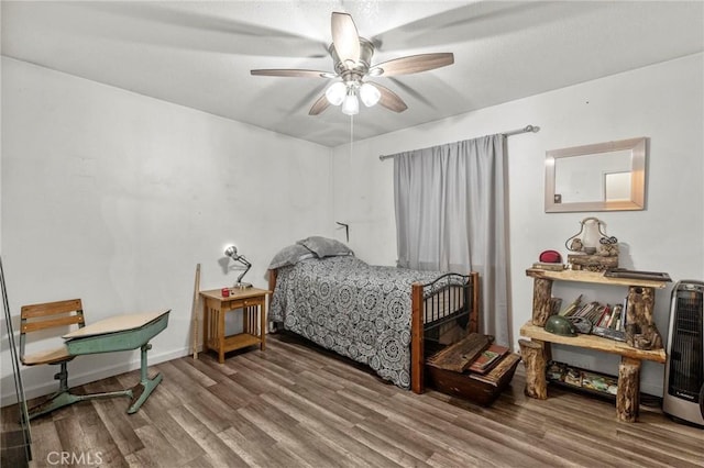 bedroom with hardwood / wood-style flooring, ceiling fan, and heating unit