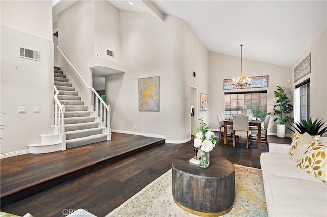 living room with dark wood-type flooring, high vaulted ceiling, and a notable chandelier