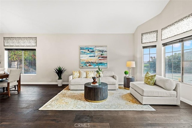 living room with dark hardwood / wood-style flooring, vaulted ceiling, and a wealth of natural light