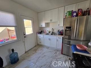 kitchen featuring stainless steel appliances, sink, and white cabinets