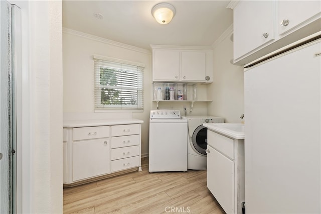 washroom with crown molding, cabinets, separate washer and dryer, and light hardwood / wood-style floors