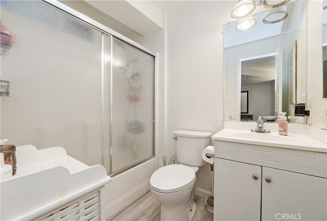 full bathroom featuring vanity, hardwood / wood-style flooring, shower / bath combination with glass door, and toilet