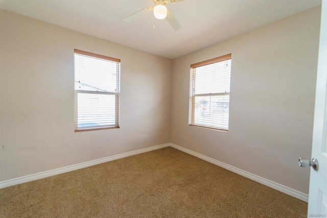 carpeted spare room with a healthy amount of sunlight and ceiling fan