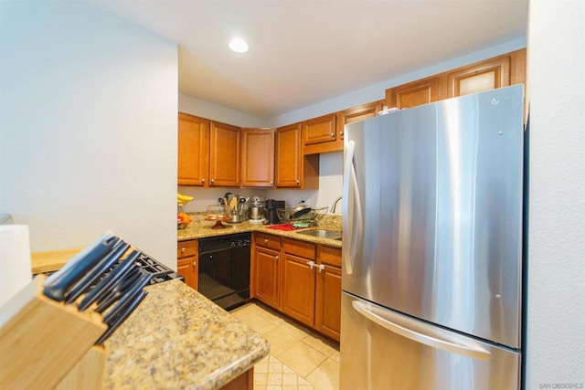 kitchen with light tile patterned flooring, dishwasher, sink, stainless steel fridge, and light stone counters