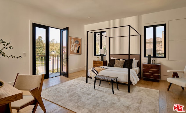 bedroom with access to exterior, light hardwood / wood-style floors, and french doors