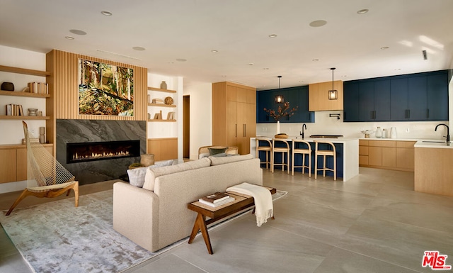 living room featuring sink, built in features, and a fireplace