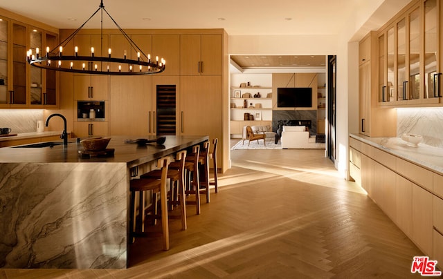 kitchen featuring decorative light fixtures, light brown cabinets, and light parquet floors