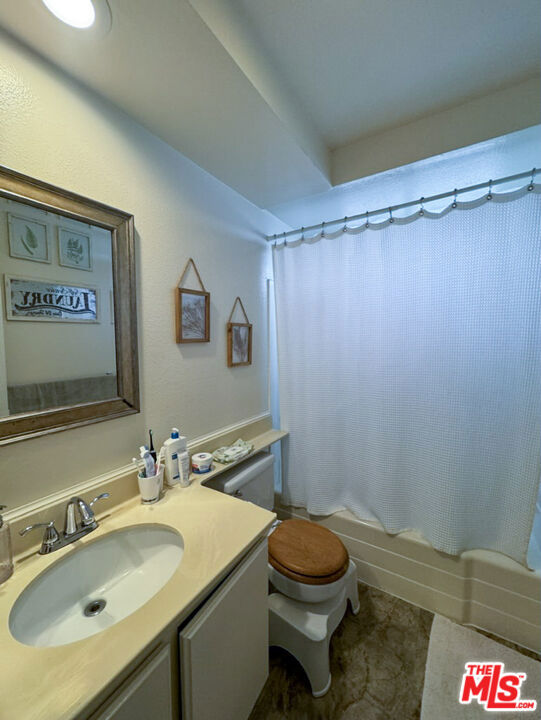 full bathroom featuring vanity, toilet, and shower / bathtub combination with curtain