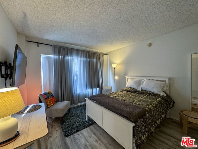 bedroom featuring wood-type flooring and a textured ceiling