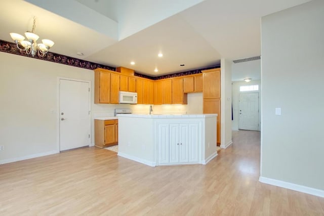 kitchen featuring an inviting chandelier, range, and light wood-type flooring