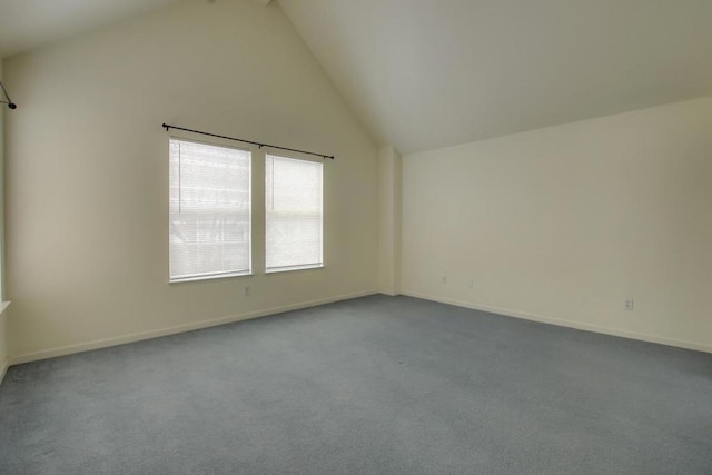 carpeted spare room with high vaulted ceiling