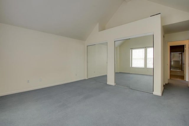 unfurnished bedroom featuring multiple closets, high vaulted ceiling, and carpet