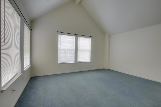 spare room featuring beamed ceiling, a healthy amount of sunlight, high vaulted ceiling, and dark colored carpet