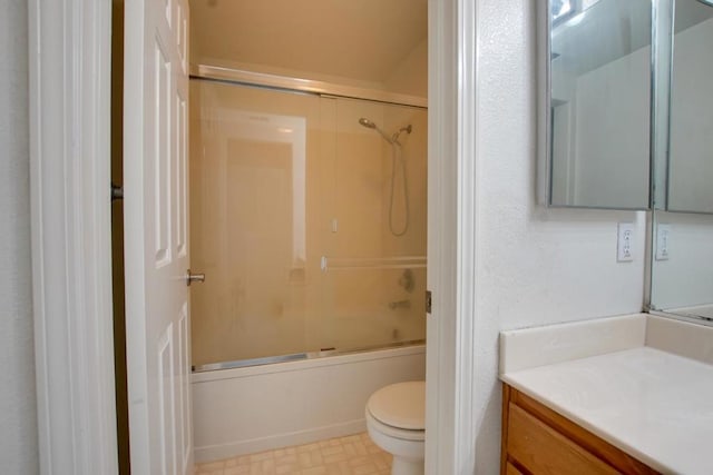 full bathroom with toilet, vanity, and bath / shower combo with glass door